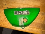 73 Suzuki TS-125 Left Side Panel Oil Tank Cover,. Fixed Price $39.00.